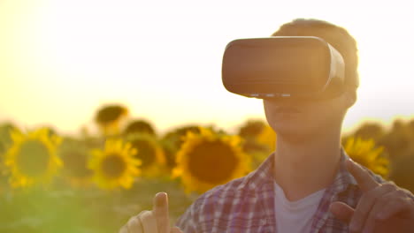 The-concept-of-technological-farming.-The-use-of-virtual-reality-in-agriculture.-A-farmer-at-sunset-uses-gestures-to-control-a-farm-and-a-field-of-sunflowers